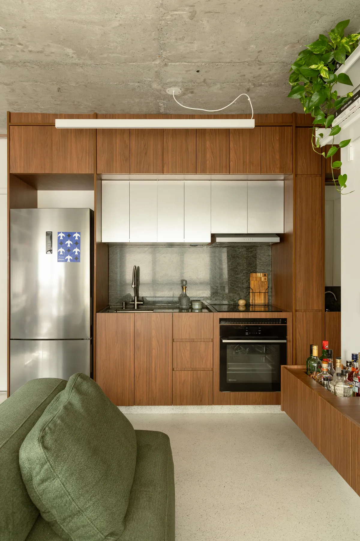 Apartamento Três Planos, cozinha compacta em madeira com o concreto do teto à mostra